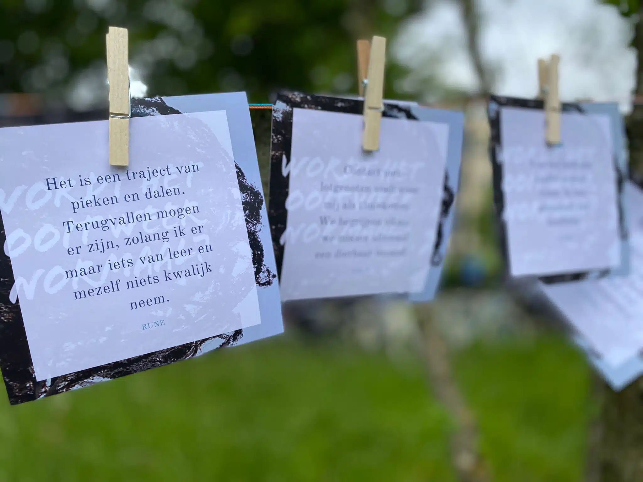 Beeld van kaartjes die met wasknijpers aan een wasdraad bevestigd zijn, in het kader van "Doodgezwegen", een vormingstraject voor jongeren omtrent rouwen